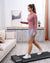 Woman using WalkingPad A1 Pro walking pad in a bright UK living room