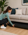 JTX MoveLight walking treadmill stored under a sofa in a modern UK living room