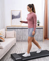 Woman using WalkingPad A1 Pro walking pad in a bright UK living room