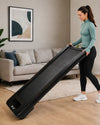 JTX MoveLight walking treadmill tilted on transport wheels in a modern UK living room